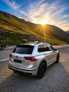 Taxi Aigle Blanc sur une route de col au coucher du soleil