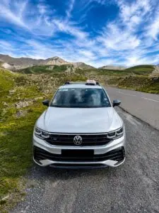 Taxi Volkswagen blanc sur une route de montagne en Maurienne