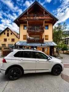 Taxi Aigle Blanc garé devant un hôtel-chalet de montagne